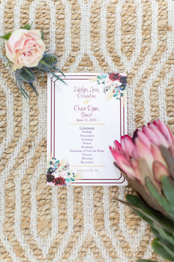 Flat lay of wedding ceremony program and flowers on textured background at hummingbird hill tx taken by cecilly elaine photography