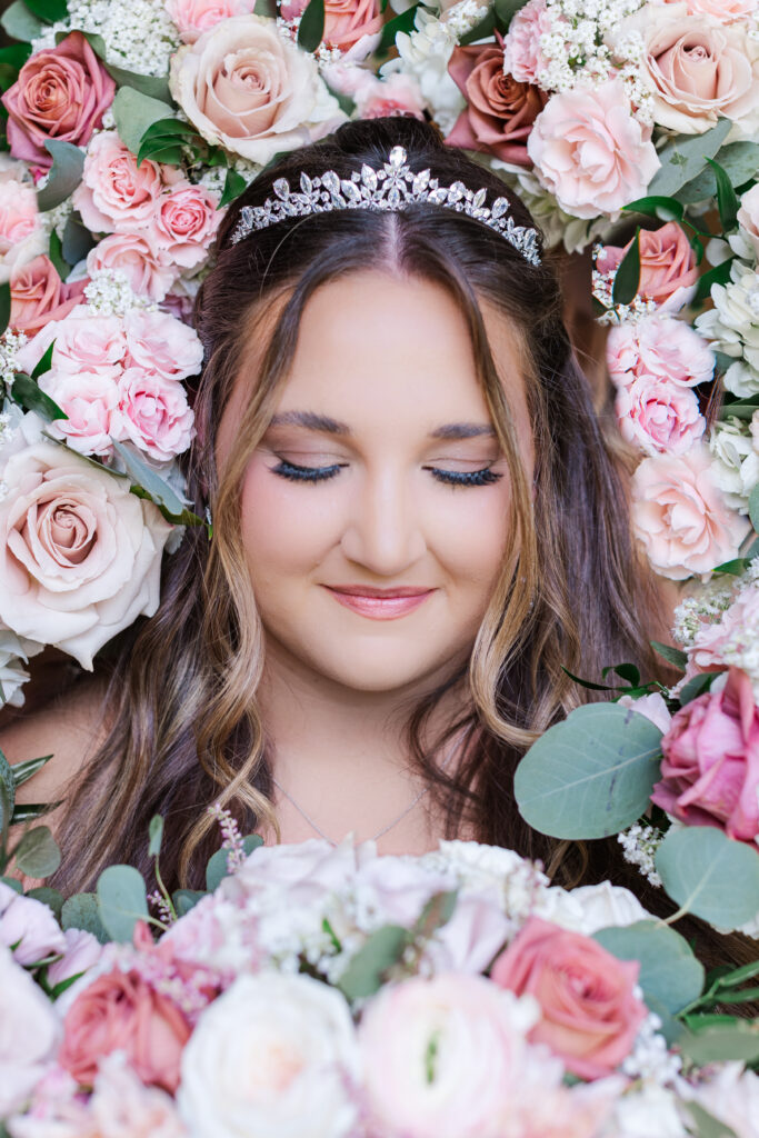 Up close photo of bride with beautiful pink and white flowers surrounding her by cecilly elaine photography