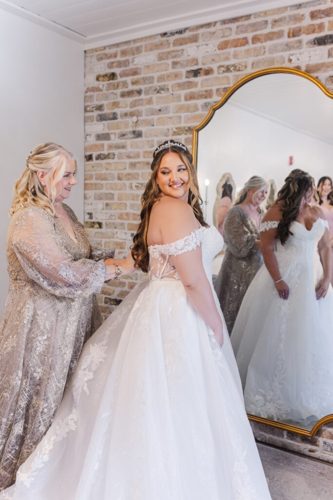 Mother of the bride buttoning her gown by cecilly elaine photography