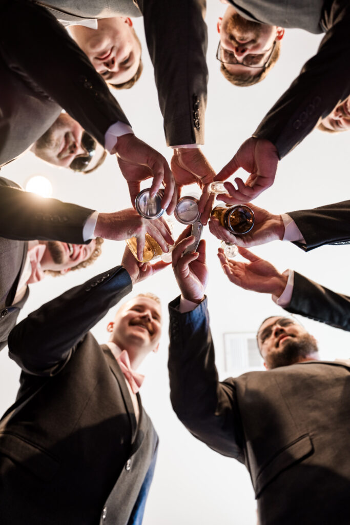 Groom and groomsman cheers by cecilly elaine photography