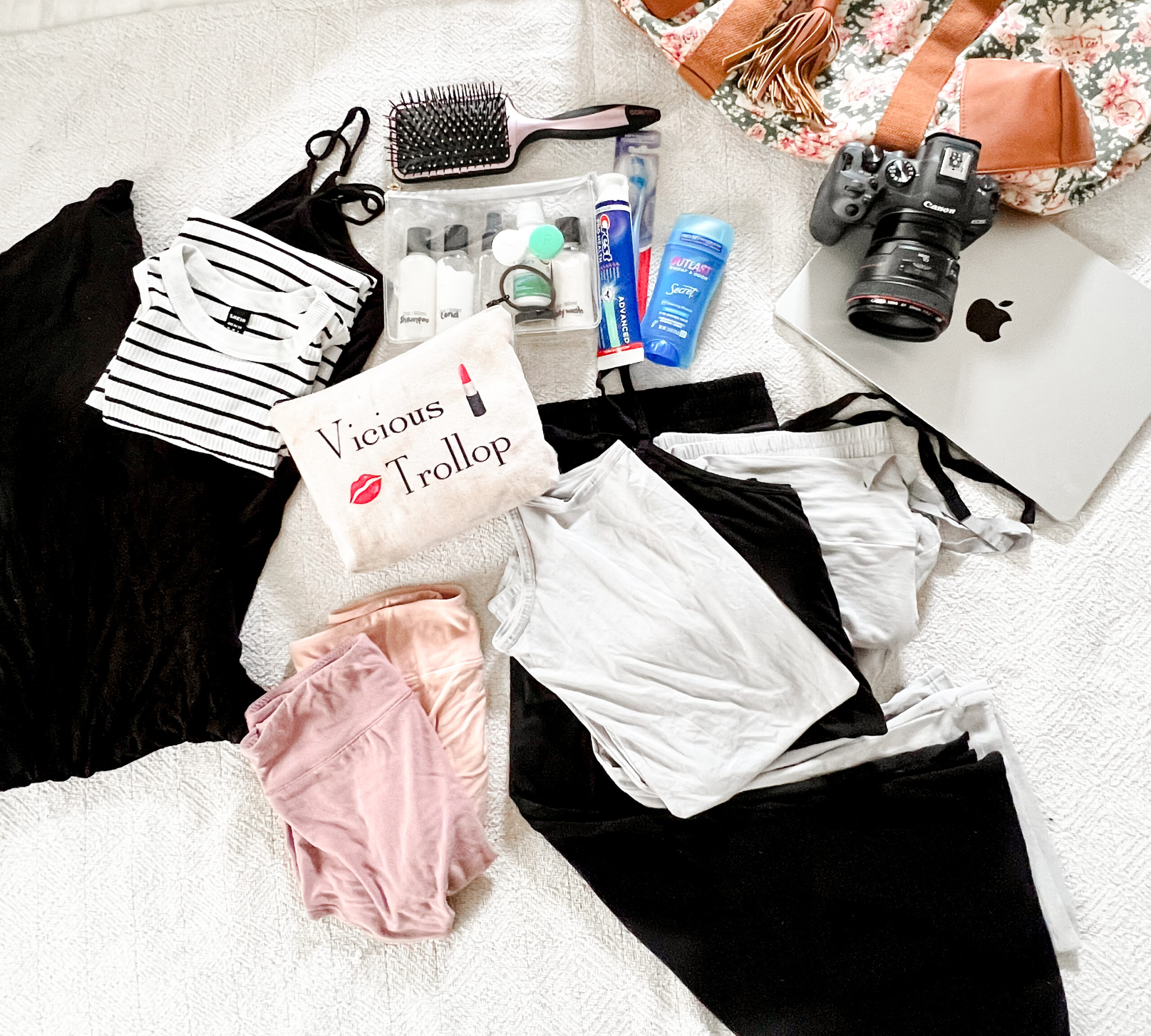 A neatly arranged flat lay of a hospital bag includes makeup bag and pajamas