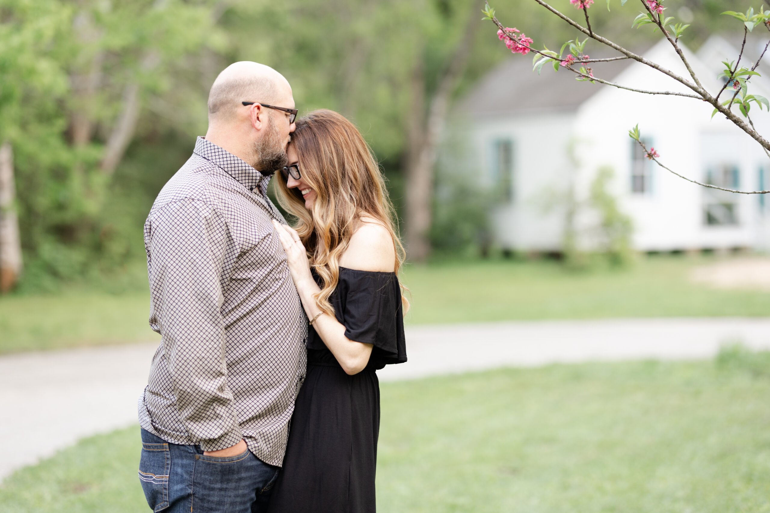 A couple share a sweeyt forehead kiss